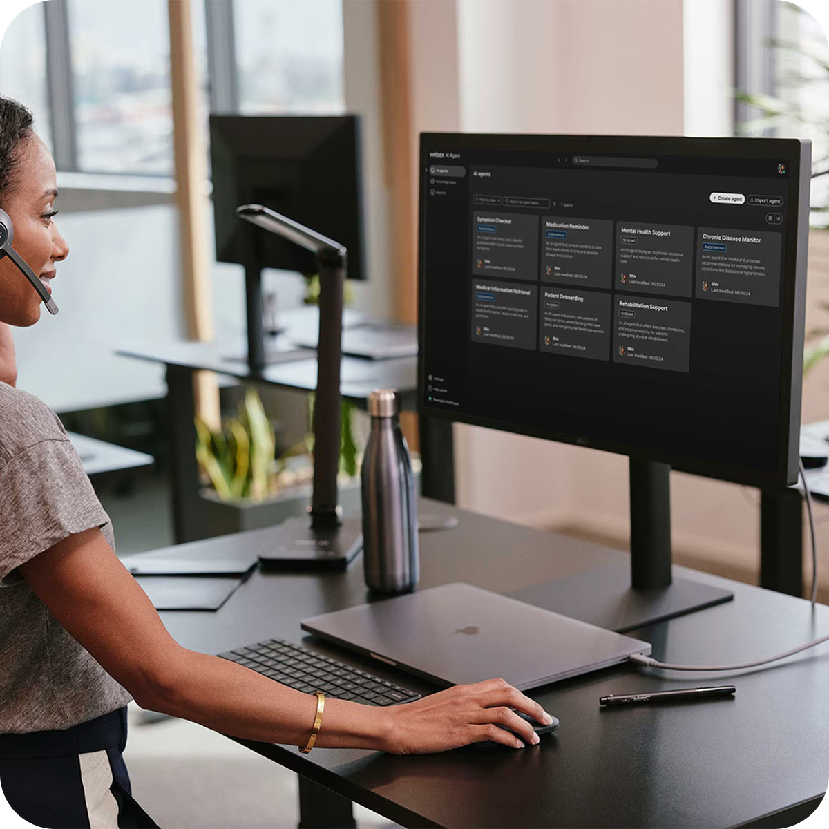 A Contact Center agent standing at a desk, operating Webex AI Agent on a screen.